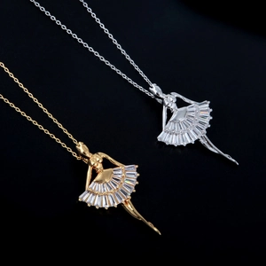 Detailed macro of gold and silver ballet dancer pendants with baguette-cut gemstones