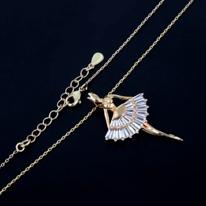 Elegant gold plated ballet dancer pendant necklace with crystal stones on black background