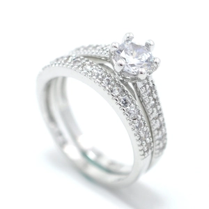 Detail of a two-piece silver-plated bridal ring set with a six-prong round zircon center