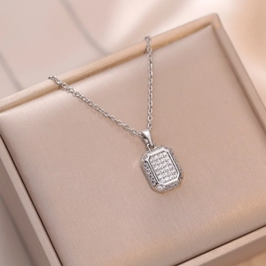 Elegant silver necklace with emerald-cut pendant encrusted in shimmering zircons