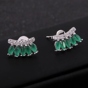 Elegantes pendientes de plata con circonitas verde esmeralda sobre un fondo negro