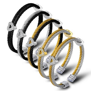 Detail of six twisted cable heart bangles in black, gold, and silver finishes