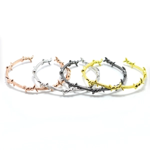Dettaglio di bracciali regolabili stile filo spinato in cinque diverse finiture metalliche