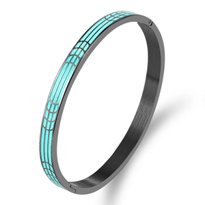Detalle de brazalete de titanio negro con diseño geométrico de esmalte azul claro y cierre