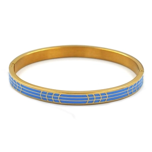Detalle macro del esmalte azul cielo en el brazalete geométrico de acero dorado