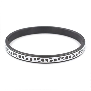 Détail d'un bracelet en acier inoxydable avec des pois émaillés noirs et blancs