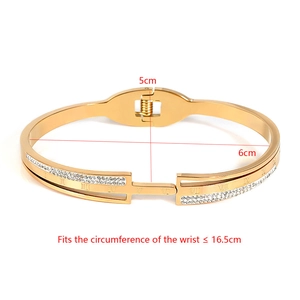 Detail view of gold stainless steel bangle with roman numerals and inlaid rhinestones