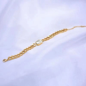Makro-Detail des goldenen Panzerarmbands mit einem großen rechteckigen klaren Edelstein