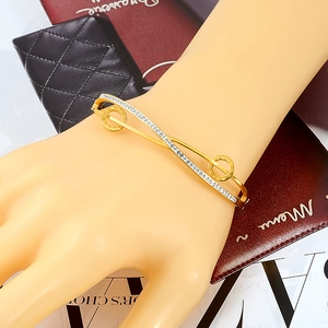 Chic gold-plated stainless steel criss-cross bangle with Roman numerals and crystals