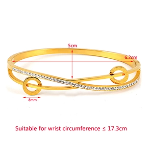 Detail of gold titanium steel bangle with Roman numeral rings and crystal accents