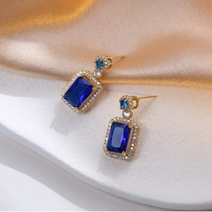 Elegante Goldohrringe mit blauem Edelstein im Smaragdschliff und Pavé-Diamanten