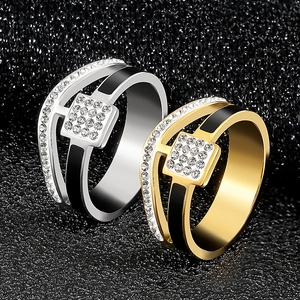 Close-up of stainless steel ring with black enamel and white zircon paving on black glitter background