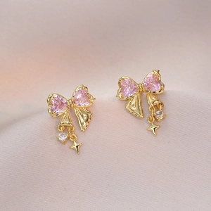 Elegant gold bow earrings with pink heart gemstones and dangling star charms