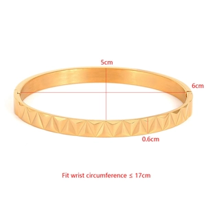 Detailed view of gold punk bracelet with pyramid studs and 5cm by 6cm inner diameter