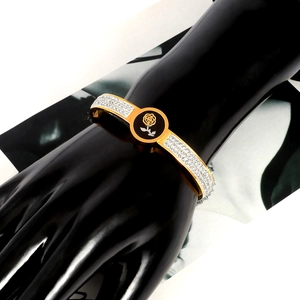 Detail of rose pattern and rhinestone inlay on a gold-plated stainless steel bangle