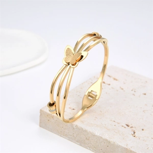 Detail view of gold butterfly bangle with multi-layer steel lines and crystal accents
