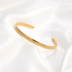 Gepolijste gouden roestvrijstalen open armband met tarwepatroon op zijden achtergrond
