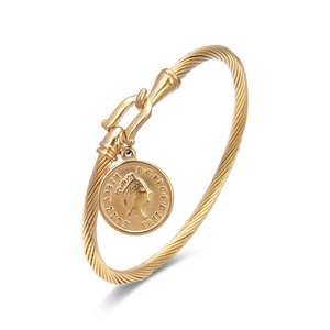 Dettaglio del bracciale a treccia dorato con ciondolo a moneta vintage Elisabetta II
