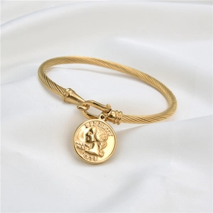 Dettaglio di un bracciale a cavo in acciaio inossidabile dorato con ciondolo Liberty 1978