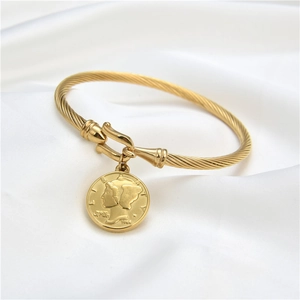 Dettaglio del bracciale rigido a fune dorata con ciondolo a moneta Liberty su raso bianco