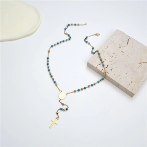 Detailed view of religious rosary necklace with blue beads and golden cross pendant