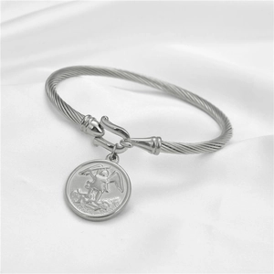 Dettaglio bracciale a cavo in acciaio con medaglia di San Michele su raso bianco