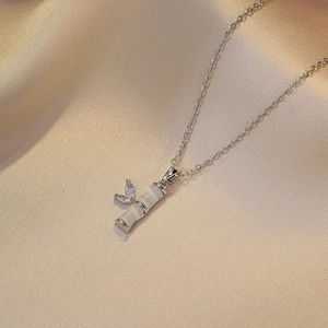 Zilveren ketting met witte kattenoog bamboe hanger en sprankelende vlinder details