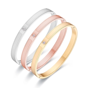 Three-piece set of brushed titanium steel bangles in silver, rose gold and gold with single diamond