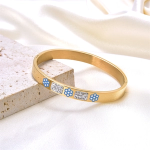 Elegant gold-plated stainless steel bangle with blue enamel flowers and crystal accents