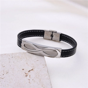 Black leather infinity bracelet with silver metal plate on a textured stone display