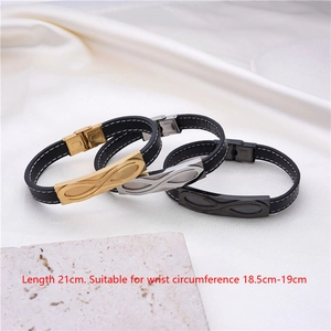 Close-up of infinity symbol bracelets in gold, silver, and black on white silk background