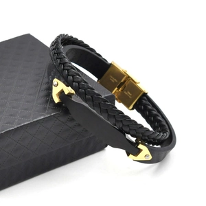 Detail eines Herren-Lederarmbandes mit goldenem Edelstahlverschluss und Flechtstruktur