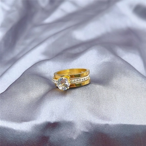 Detalle macro del conjunto de tres anillos de titanio dorado con circón central grande