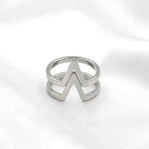 Polished silver V-shaped hollow geometric ring for women on a white silk background