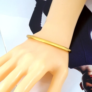 Vue détaillée d'un bracelet jonc ouvert minimaliste en acier inoxydable plaqué or 18 carats