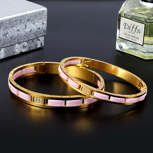 Detail of gold-plated stainless steel hinge bangle with pink ceramic and inlaid rhinestones