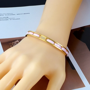 Golden stainless steel cuff bracelet with pink ceramic blocks and crystal accents