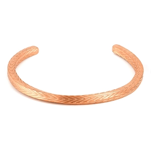 Dettaglio macro del bracciale aperto oro rosa con texture geometrica a spina di pesce