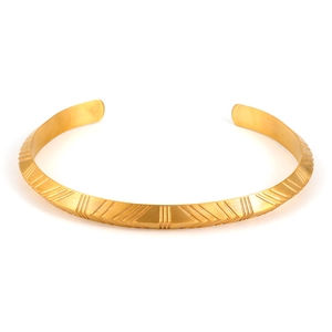 Dettaglio del bracciale rigido in acciaio inossidabile oro opaco con motivi geometrici