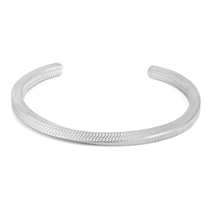 Dettaglio del bracciale rigido in acciaio argento con trama industriale e incisioni oblique