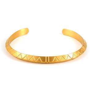 Dettaglio macro della trama geometrica dorata sul bracciale a fascia in acciaio inox