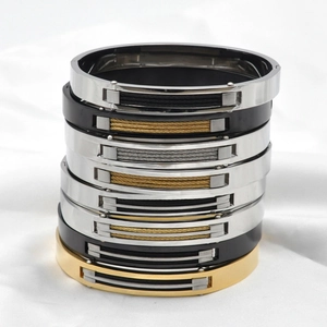Vertikaler Stapel aus Titanstahl-Kabelarmbändern in Silber, Gold und Schwarz im Industriedesign