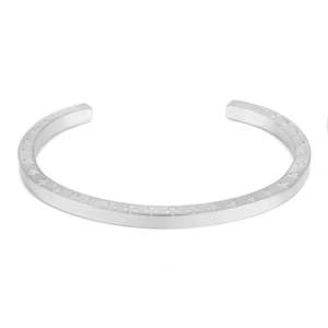 Dettaglio di un bracciale aperto in acciaio inossidabile con motivi a stella