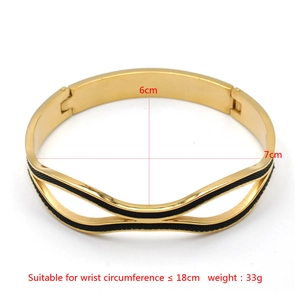 Vue détaillée du bracelet doré à vagues avec insert noir et mesures de taille