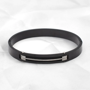 Detail eines mattschwarzen Titanstahl-Armbands mit Silbereinlagen und Industrie-Nieten