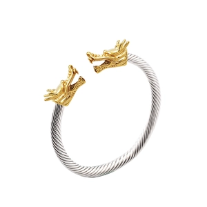 Vista macro de pulsera retro de alambre de acero trenzado con cabezas de dragón doradas