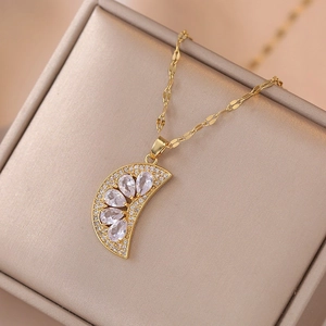 Elegant gold fruit slice pendant necklace with clear zircons on a satin jewelry box