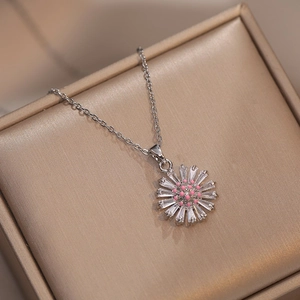 Elegant silver flower necklace with pink center and crystal petals on jewelry box