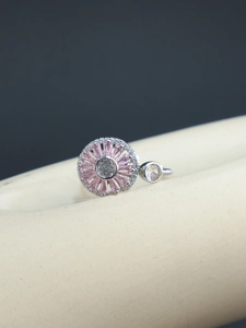 Gros plan sur bague en argent avec motif floral en zircon rose et sertissage radiant