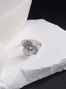 Nahaufnahme des silbernen Rosenrings mit Pavé-Kristallen auf weißem Stein